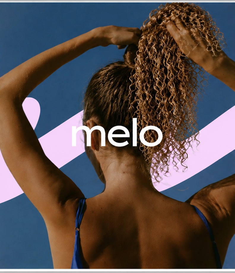 melo — athlete tying her curly hair against a deep blue backdrop